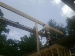 Carpenter setting a ridge beam over a new addition frame — Ice Dam Removal by Roofing Brothers in Ahsahka