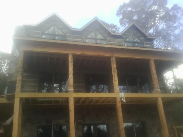 Dormers and porch framing on a large log home under construction — Roof Coating work by our crew in Ahsahka