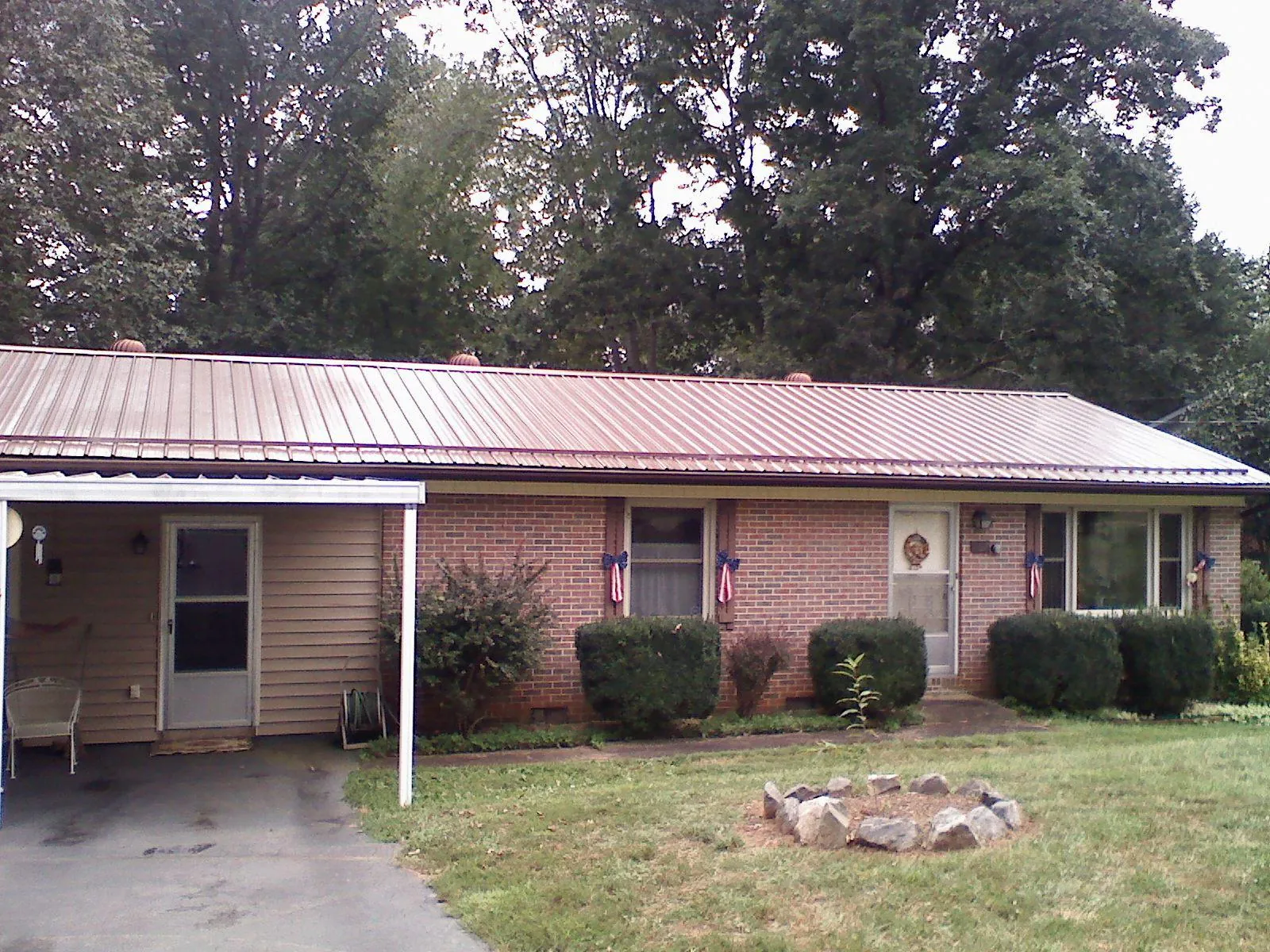 Bronze metal roof and carport on a brick ranch home — Roof Repair work by our crew in Ahsahka